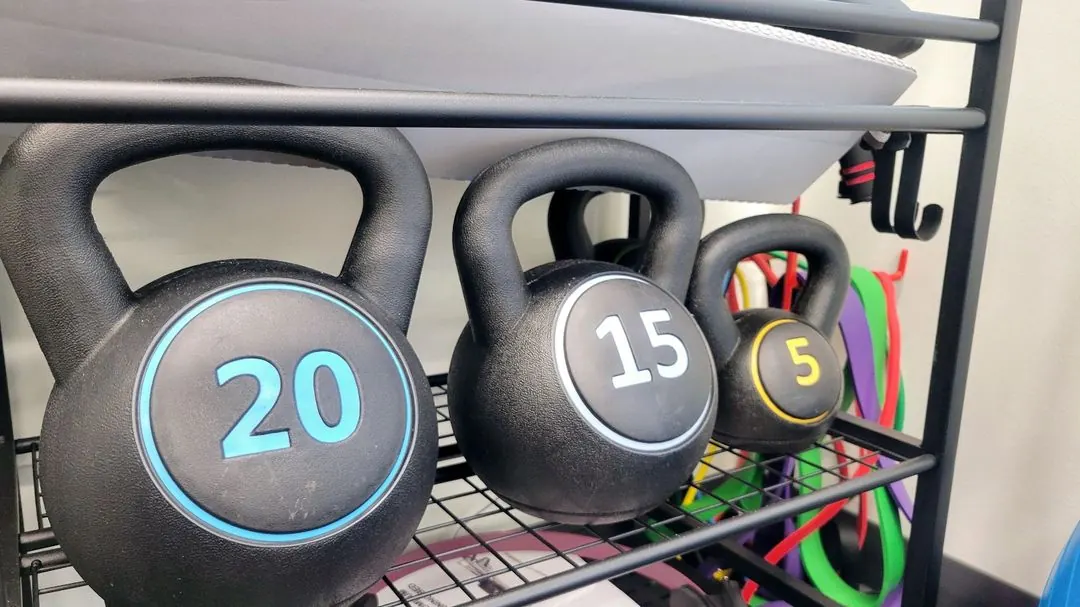 Kettlebells and resistance bands on an exercise equipment rack